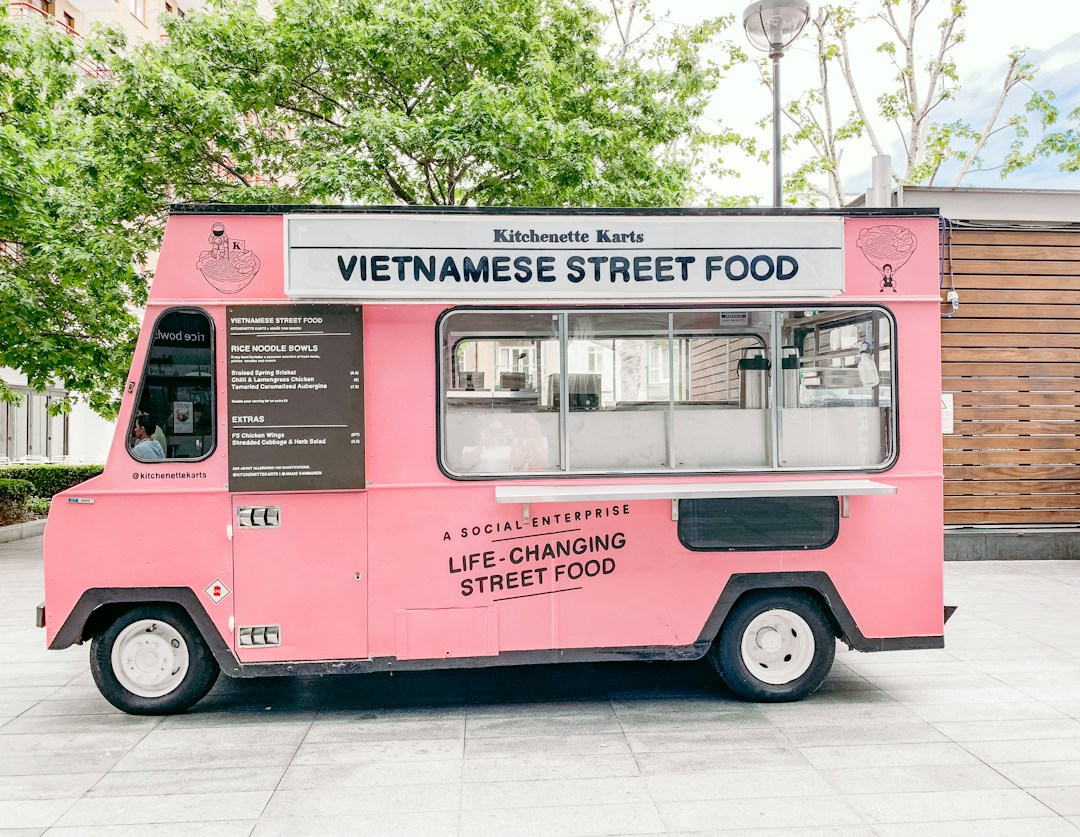 Pink food truck with Vietnamese street food menu and branding.