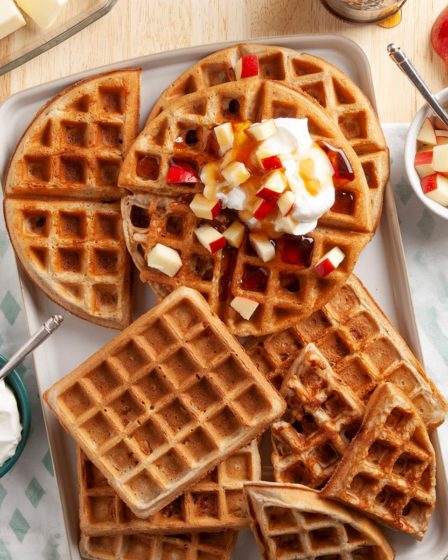 Apple spice waffles with apples, syrup, and whipped cream for a cozy fall dessert.