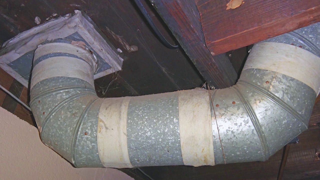 Damaged and aging HVAC ductwork with cracked sealant and tape.