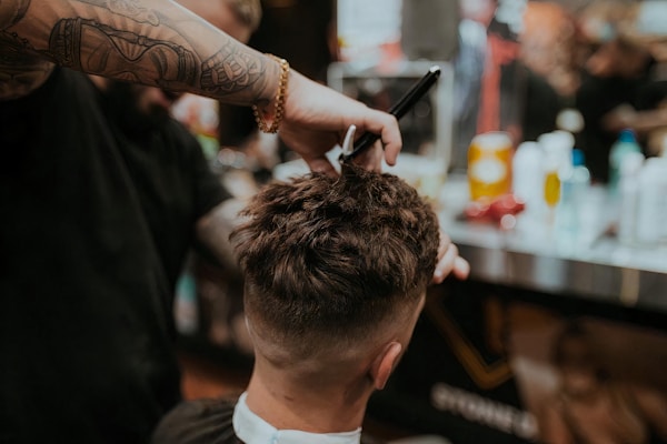 Barber cutting man's hair, personalized haircut styling.