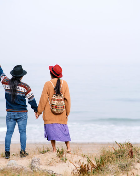 Couple near the sea, looking out at the water, representing home and lifestyle.