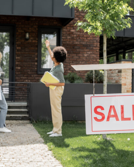 African American real estate agent showing house for sale, home selling guide.