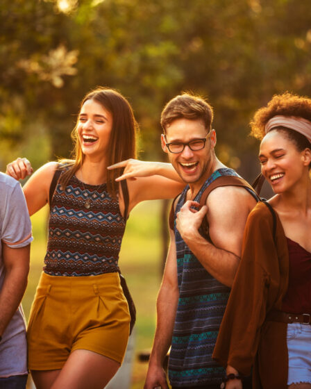 Group of friends laughing and enjoying festival fashion and experiences.