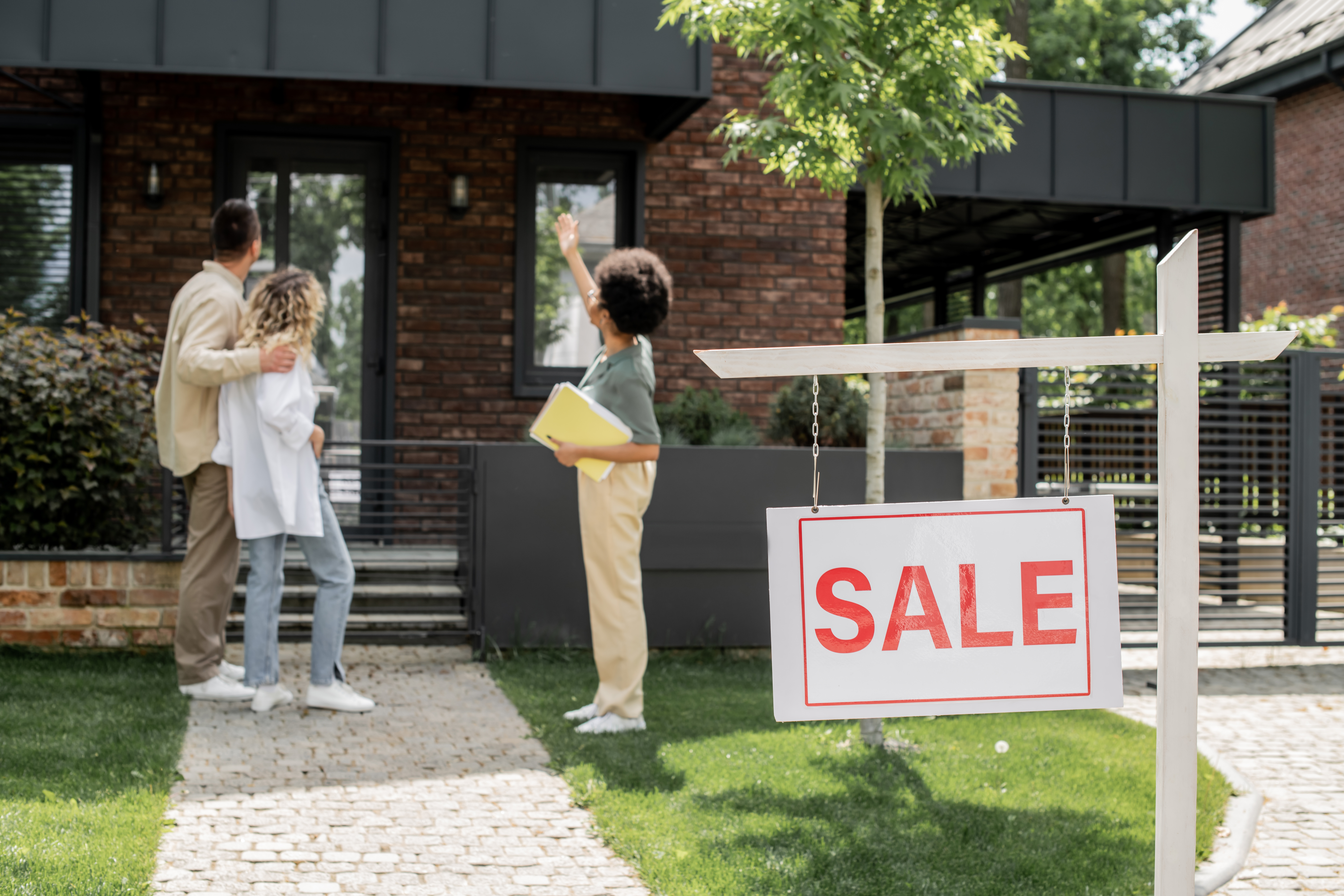 African American real estate agent showing house for sale, welcoming new homeowners.
