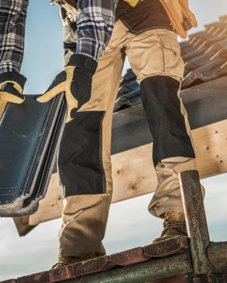 Roofer installing ceramic roof tiles, home improvement and maintenance.