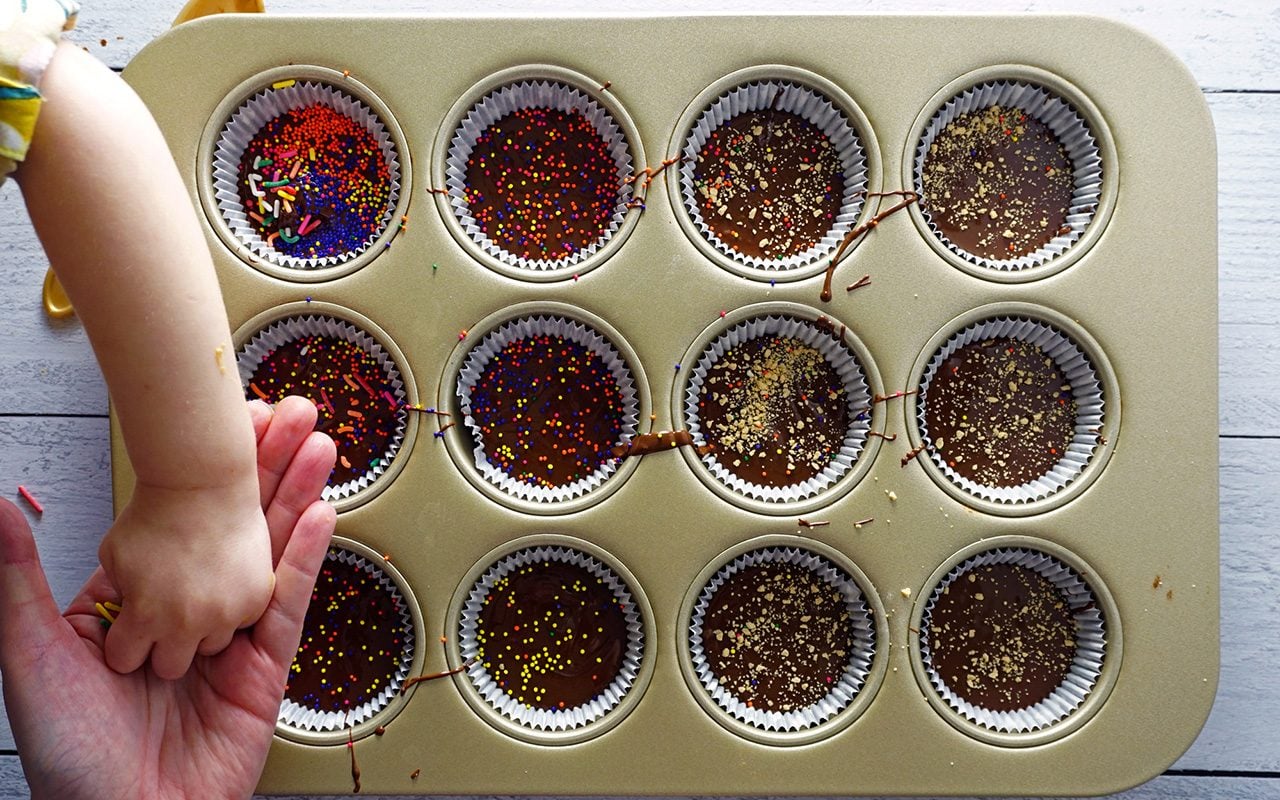 decorating peanut butter cups with sprinkles